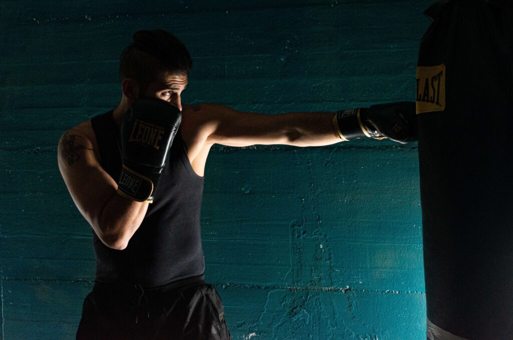 Boxe Genève - Coach de boxe qui frappe contre un sac de boxe