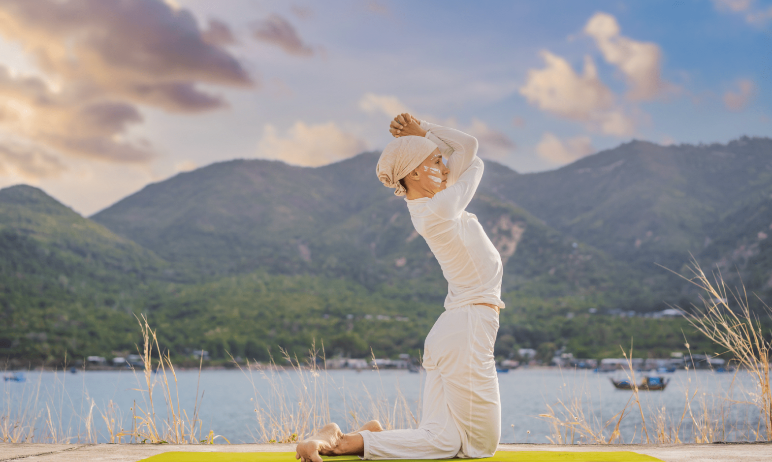 Femme assise, séance de Kundalini Yoga, tapis de yoga, montagne en arrière plan