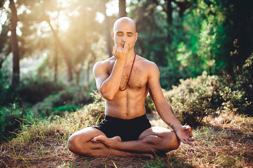 Homme en position de yoga effectuant des techniques de Pranayama