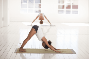 Femme effectuant la posture de yoga du chien tete en bas dans un studio de yoga.