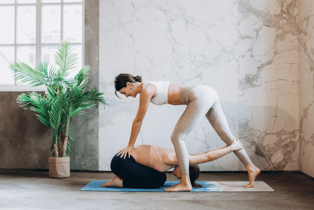 Femme effectuant la posture de yoga balasana avec une coach diplômée