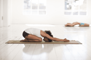 Femme pratiquant le balasana, une posture de yoga relaxante.