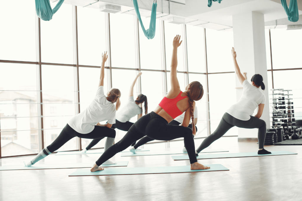 Séance collective de Pilates dans un studio accompagnée d'un coach de pilates