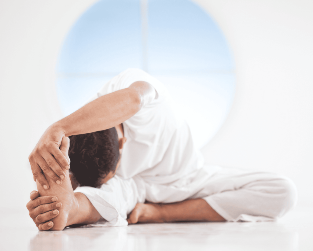 Homme en tête au genou avec étirement dans un studio de yoga lumineux.