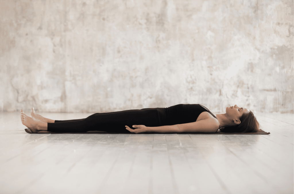 Femme en Shavasana dans un studio de yoga.